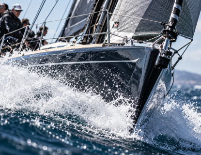 Racing sailboat splashing through waves